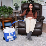 Woman sitting on a brown leather recliner using the Polar Active Ice® 3.0 38" x 22" Blanket Cold Therapy System under her.