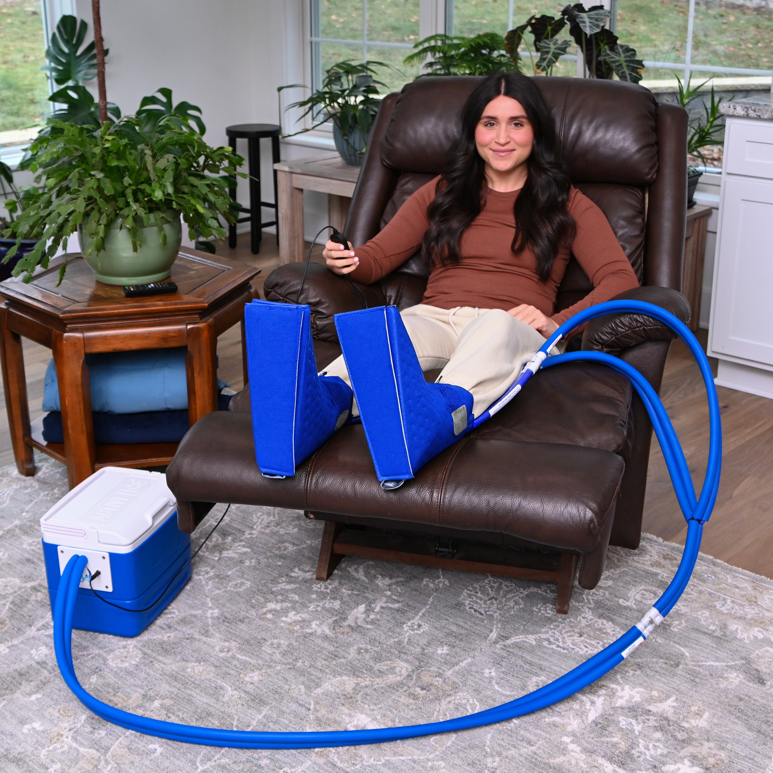 Woman sitting in recliner chair using the Polar Double Active Ice® Upper Foot & Ankle Cold Therapy System on her feet