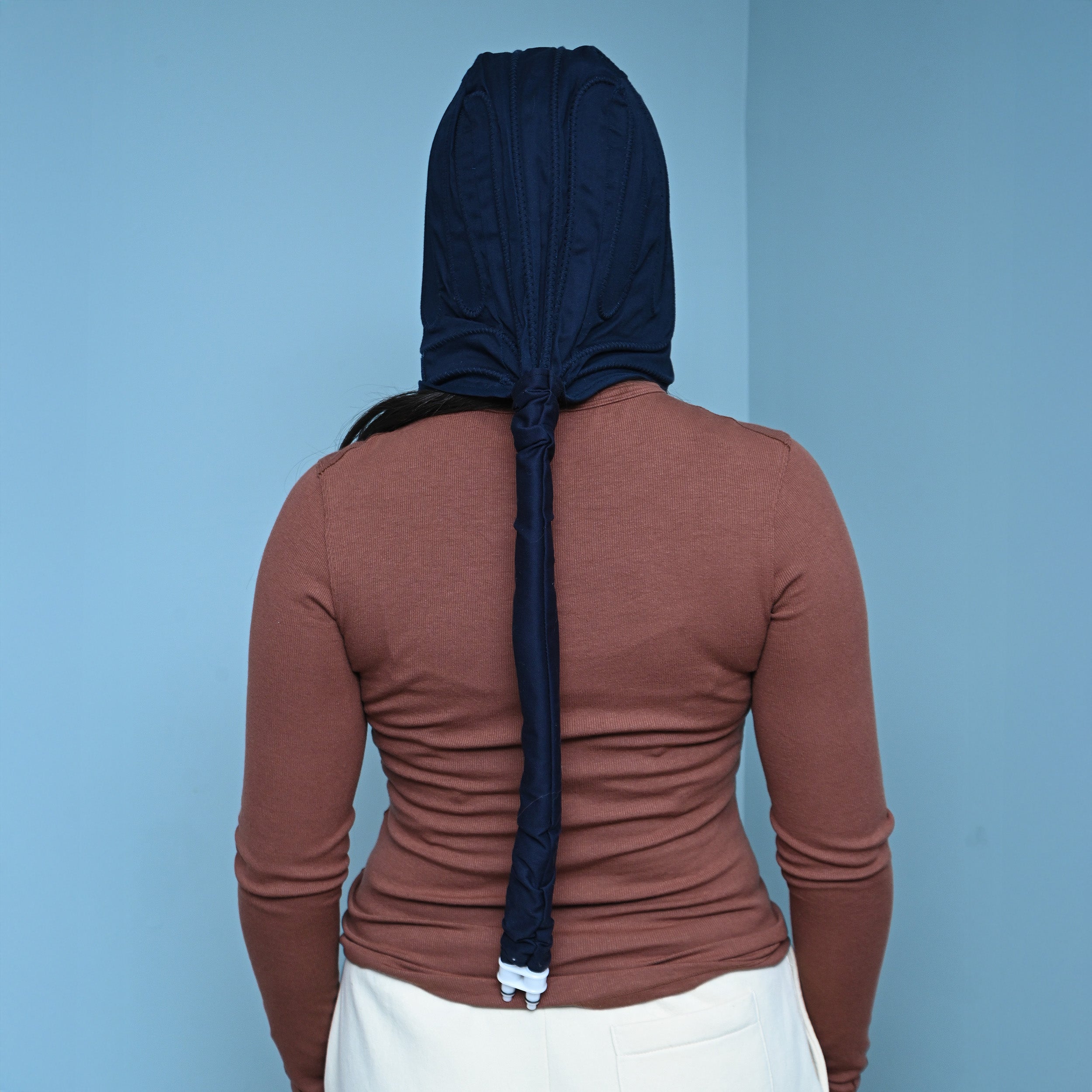 Woman wearing the Polar Active Ice® 3.0 Head Cold Therapy Cap (Therapy Cap Only) on her head showing the back tubing.