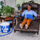Woman wearing an extended back & hip Active Ice® Cold Therapy System while sitting in a brown leather recliner