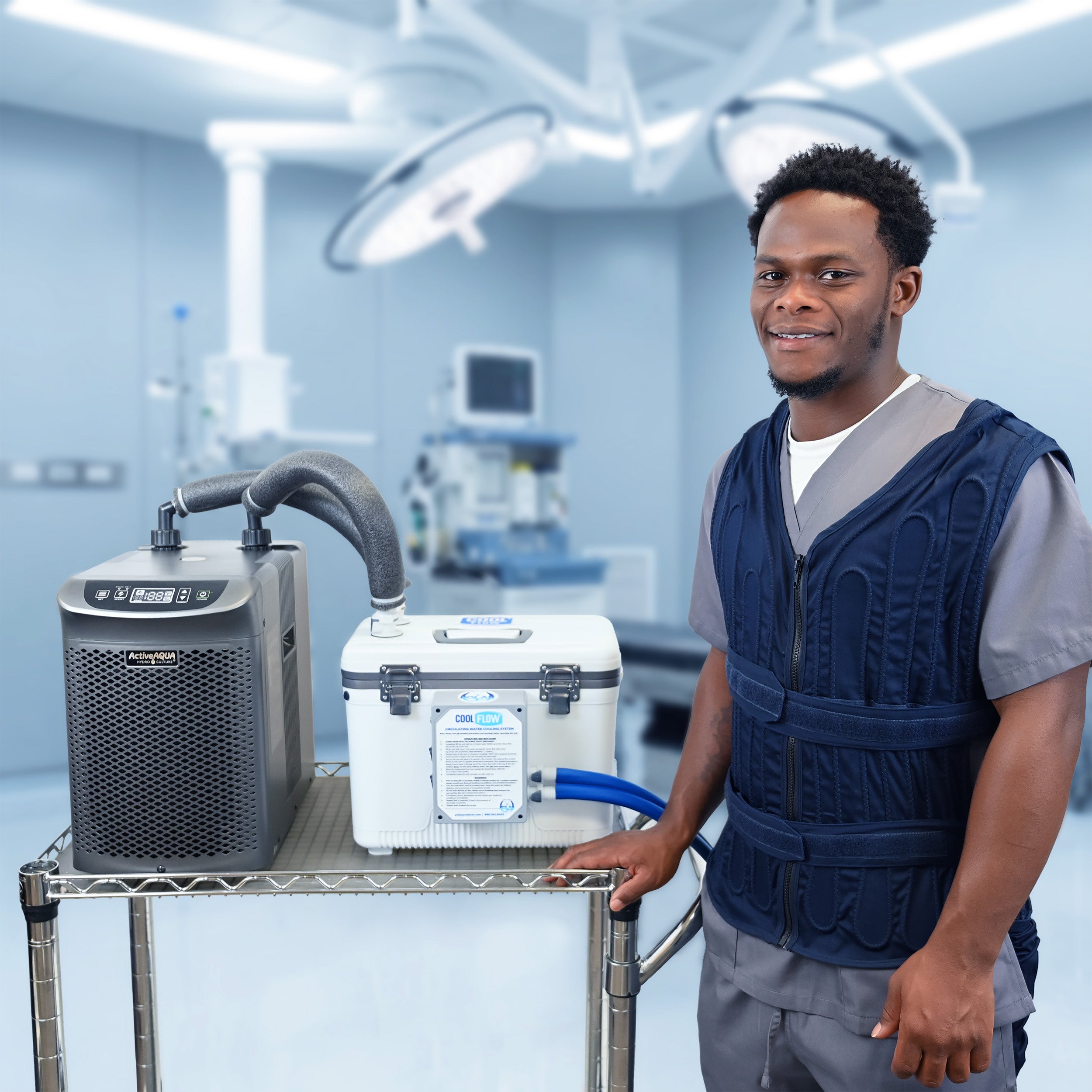 A man in medical scrubs stands beside a tiered cart holding two pieces of equipment: a dark gray Arctic Chiller with a hose and a white 13-quart cooling reservoir, set against a blurred operating room background. The cooling reservoir is attached to the adjustable circulating cooling vest that the man is wearing.