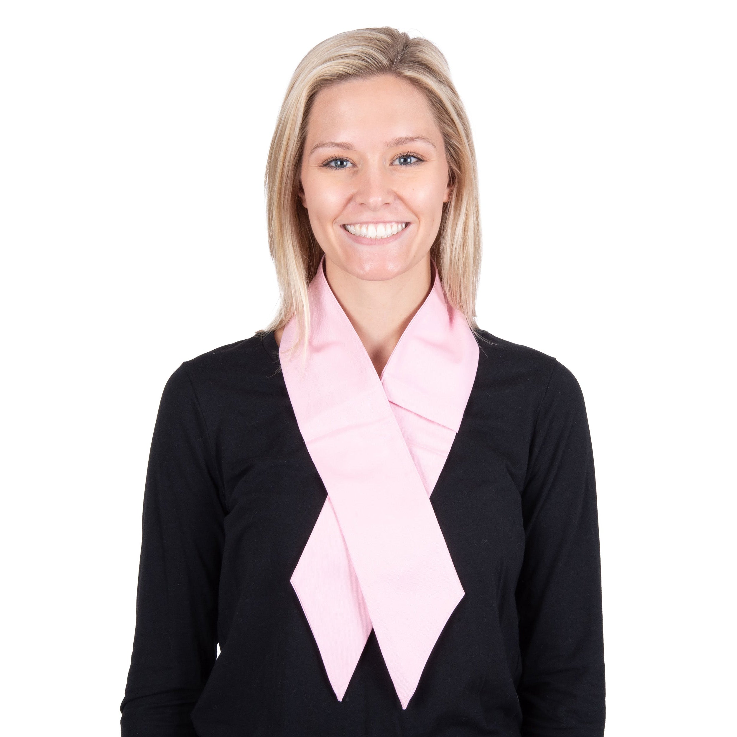 A smiling blonde woman wearing a light pink deluxe cooling neck wrap over a black long-sleeve top, photographed against a solid white background.