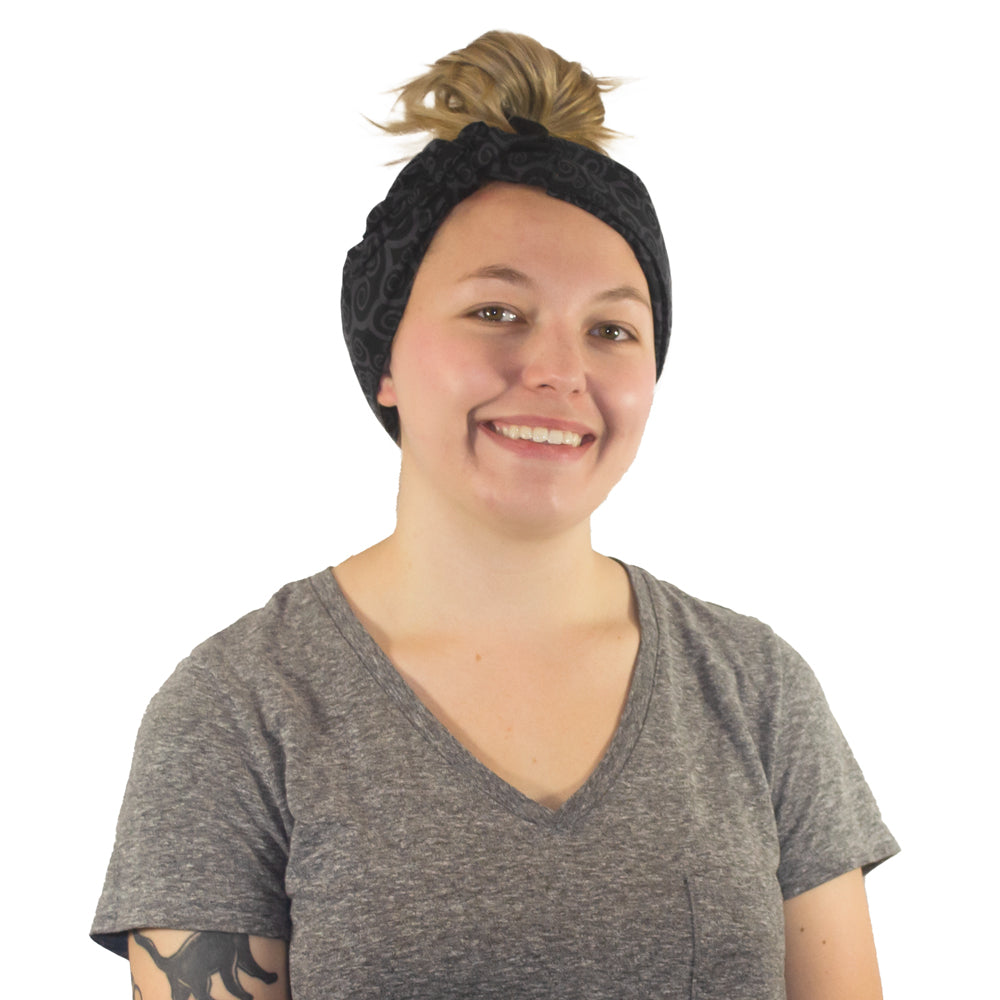 A smiling woman with short blonde hair wearing a black patterned Cooling Head Wrap.