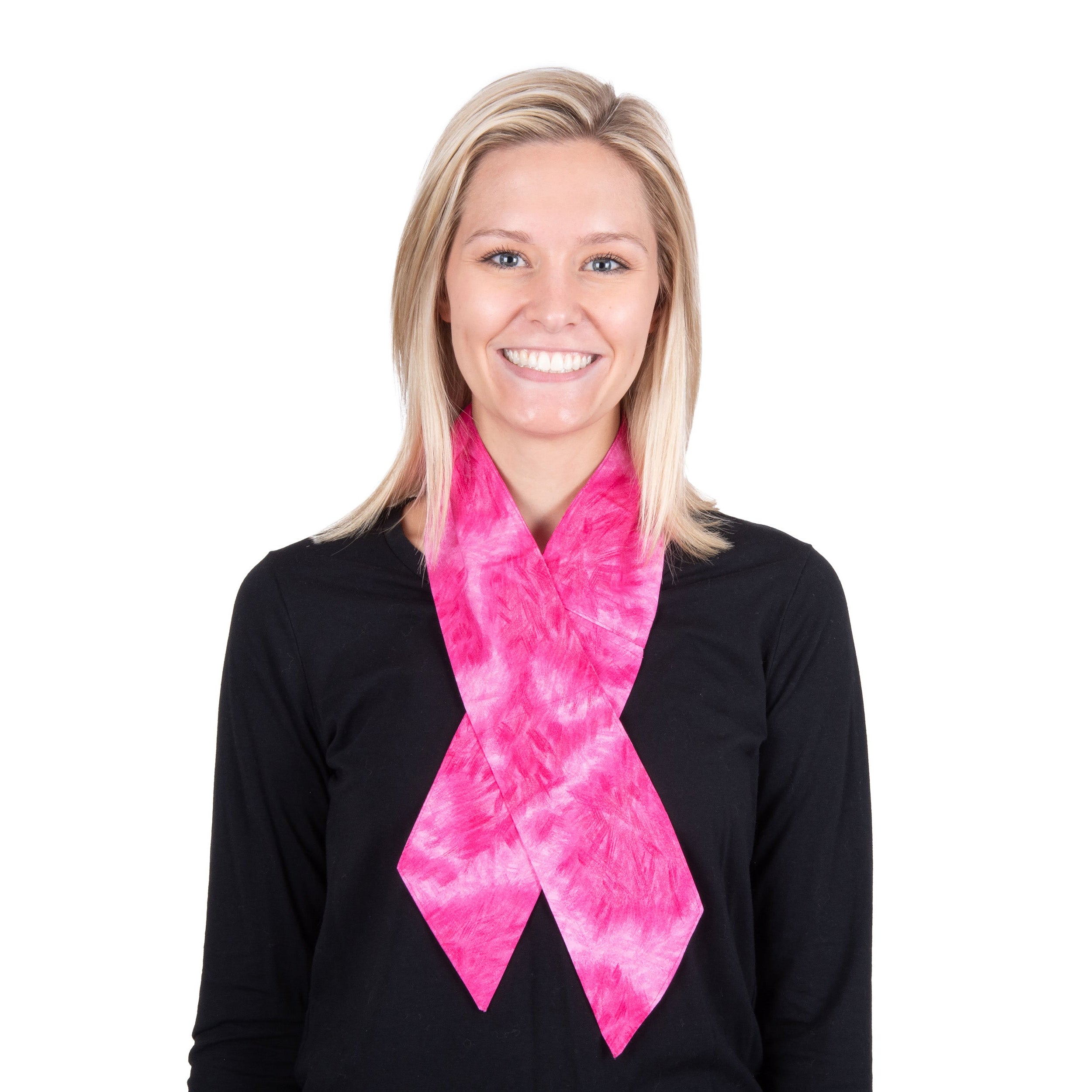 A smiling blonde woman wearing a bright pink tie-dye cooling fashion neck scarf and a black long-sleeve shirt, photographed against a solid white background.