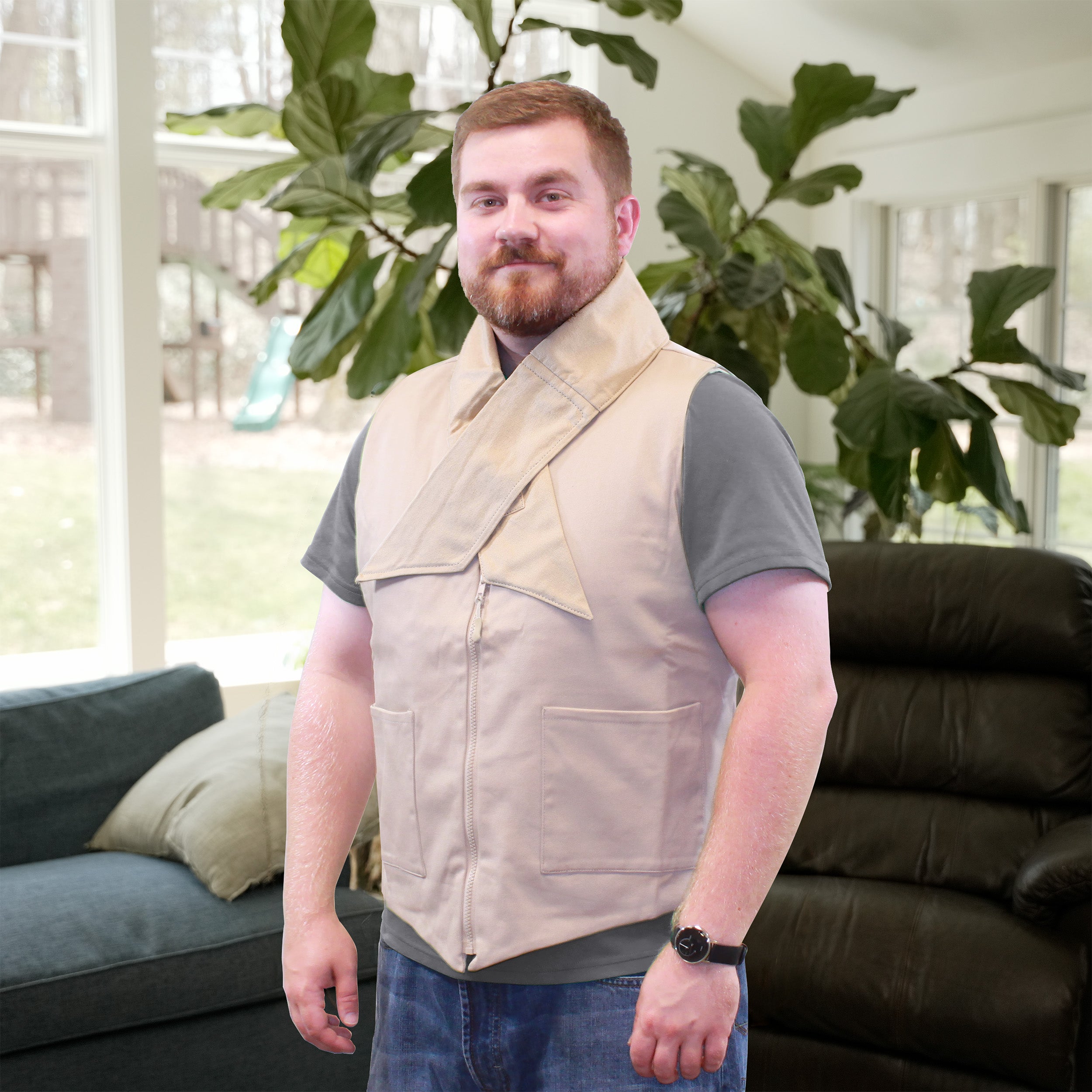 Man wearing a beige fashion cooling vest and deluxe cooling neck wrap in a living room with green plants and a couch.