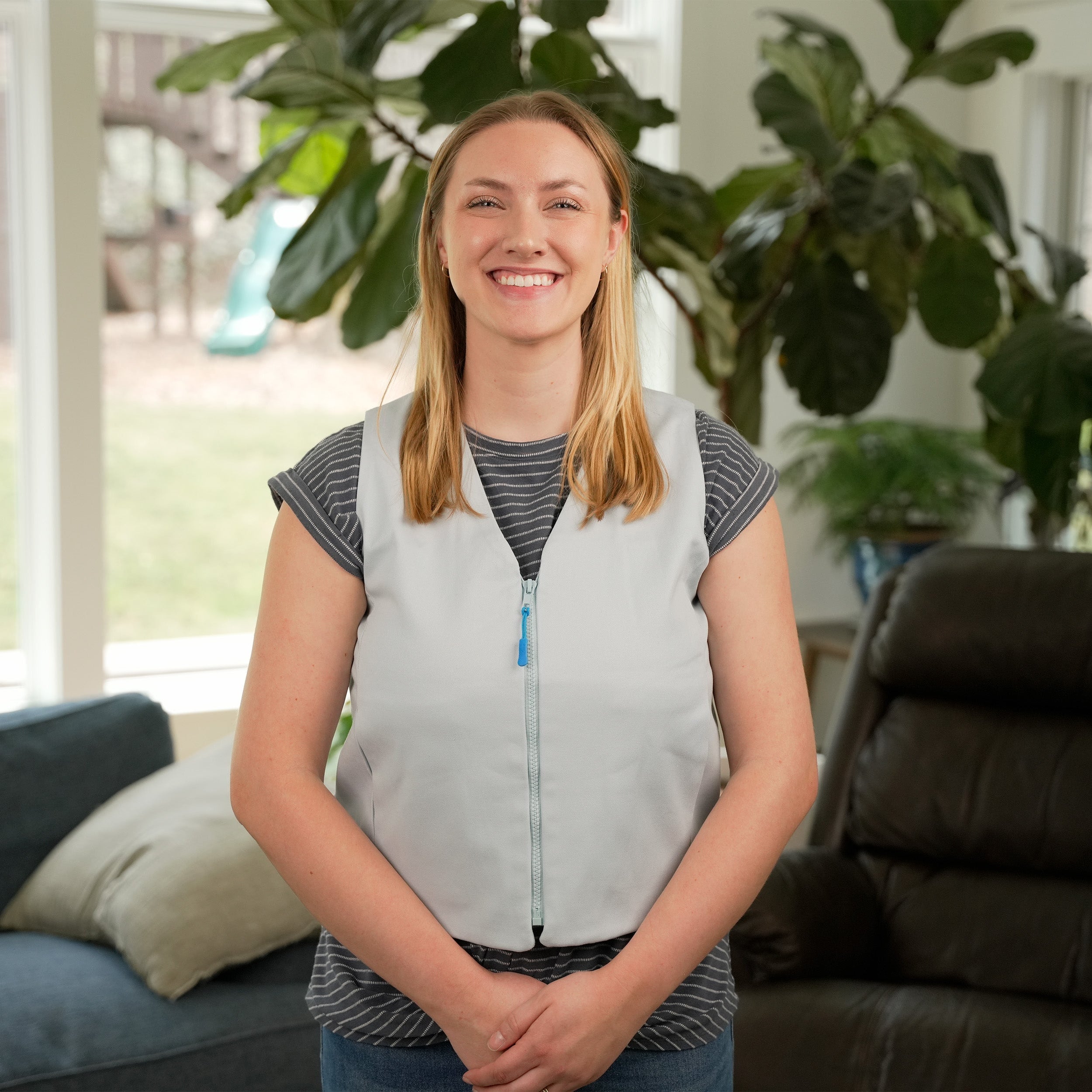 Woman standing in a living room wearing a Light Blue Cooling Fashion Vest with Kool Max® packs