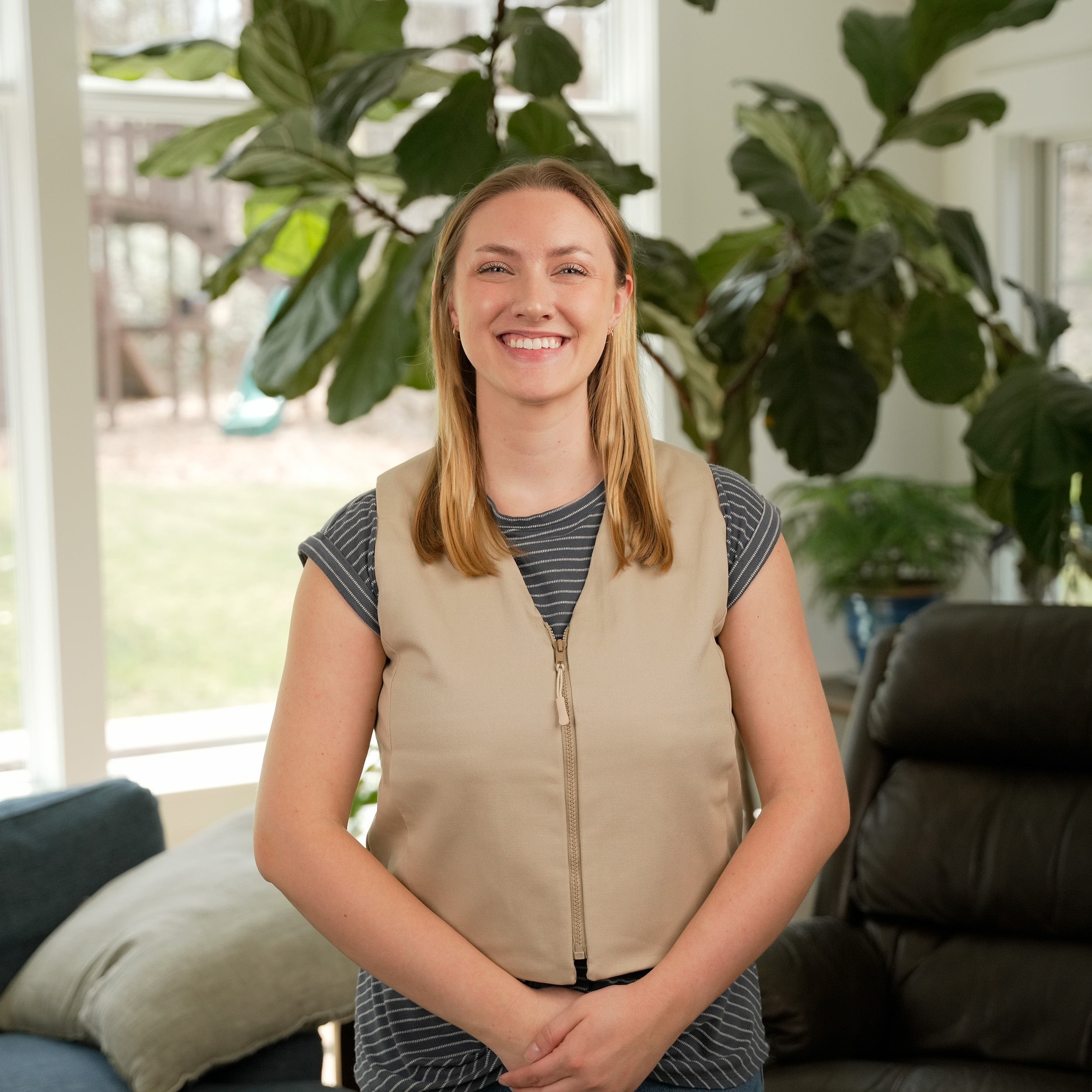 Woman standing in a living room wearing a Khaki Cooling Fashion Vest with Kool Max® packs
