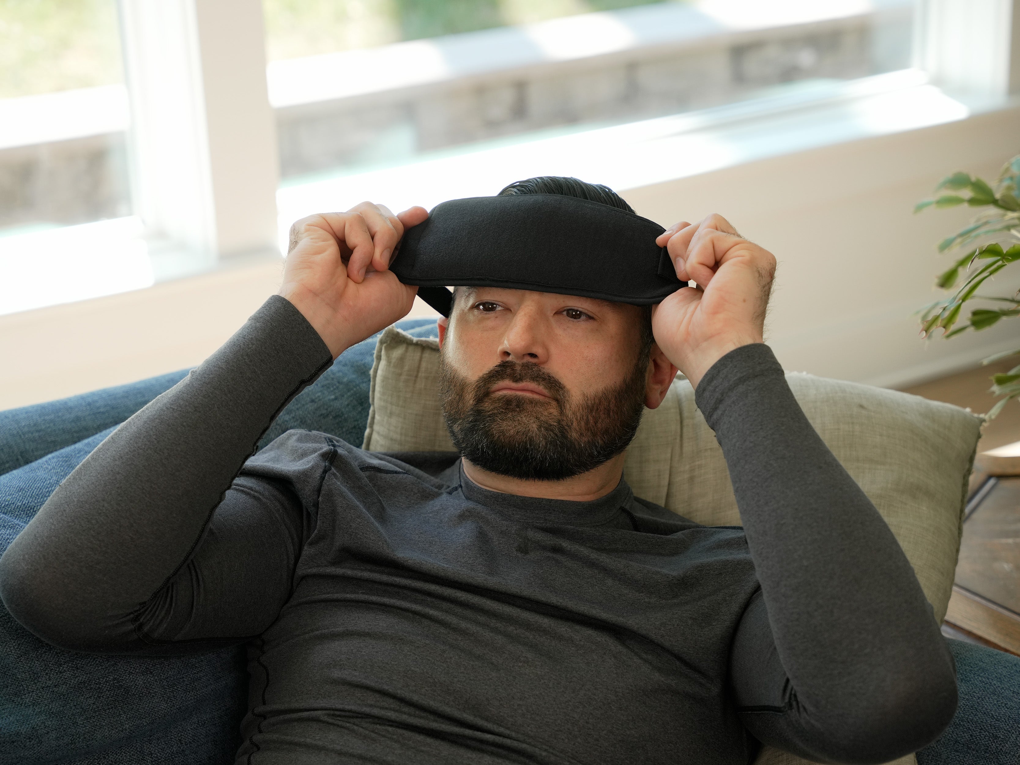 Man wearing a black Soft Ice® Head Wrap in a living room setting