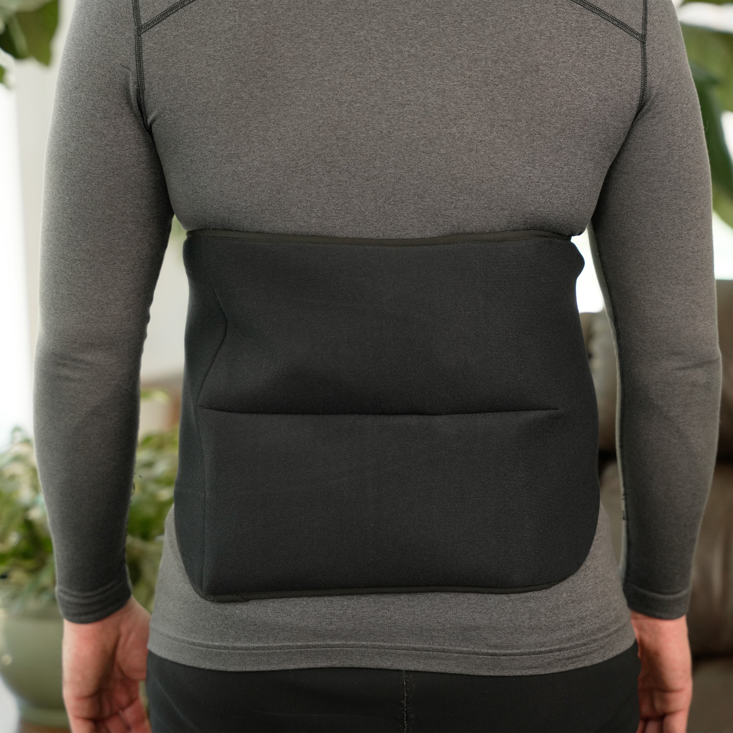 Person wearing a gray shirt and wearing a Soft Ice® Lumbosacral Wrap on lower back.