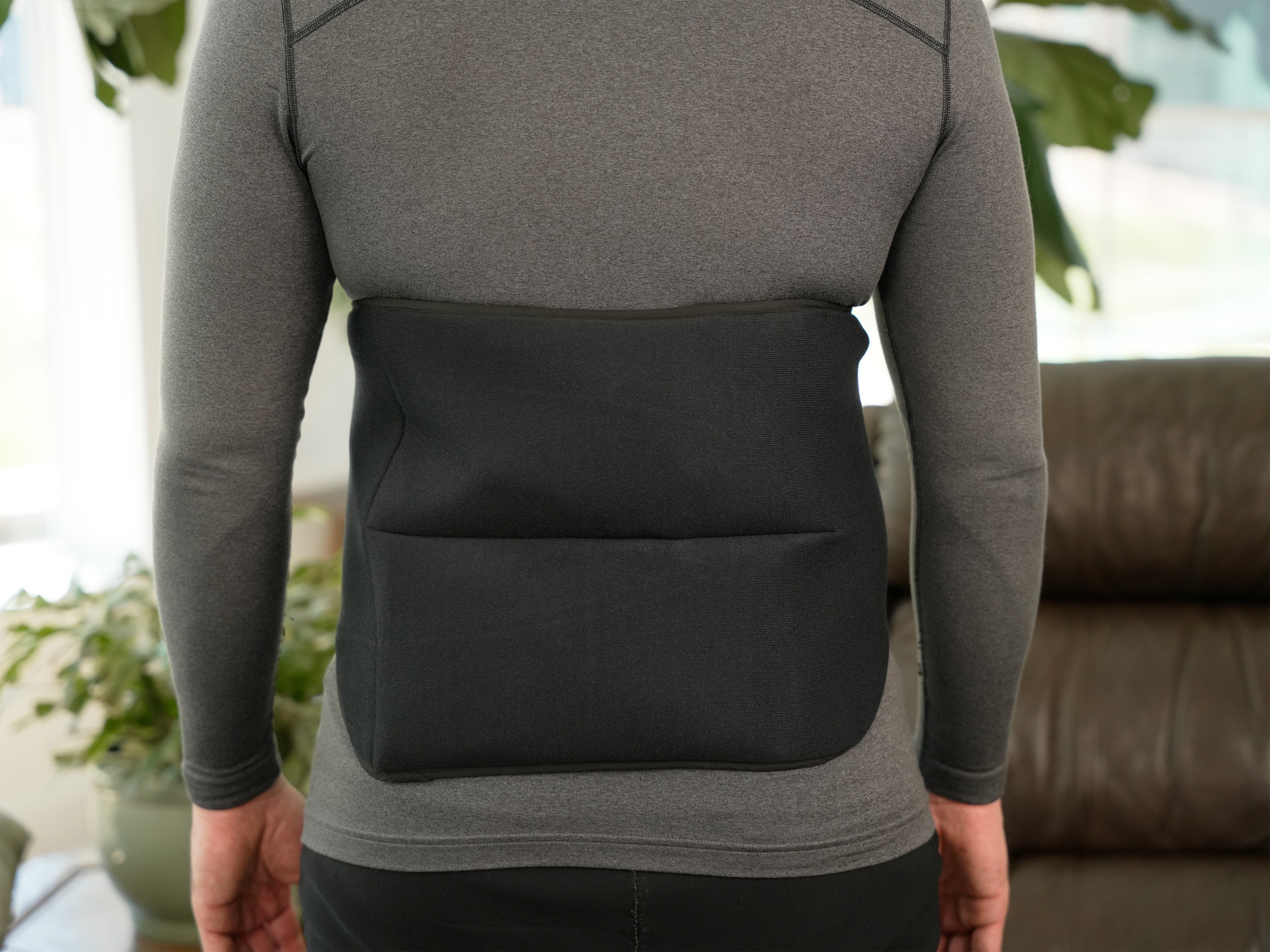 Person wearing a gray shirt and wearing a Soft Ice® Lumbosacral Wrap on lower back.