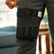Close-up of a person wearing dark gray pants with a black Moist Heat Thera-Temp Wrap around the upper leg, plus a small white product tag.