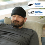 A man reclining on a couch wearing a black Soft Ice® head and jaw wrap. Two callout bubbles on the right show included accessories: a soft ice pack and a Thera-Temp eye and sinus wrap.