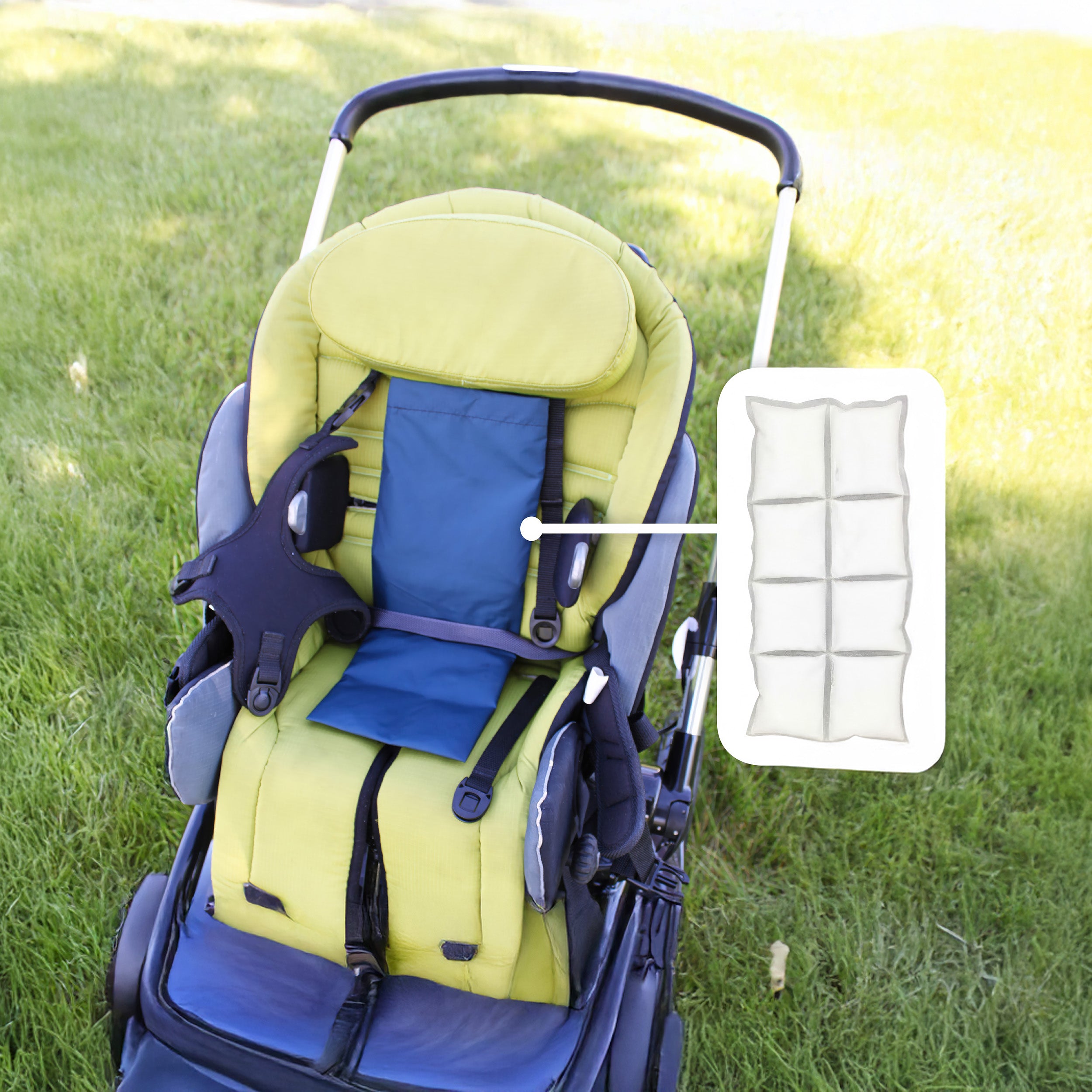 A stroller with a yellow-green and navy blue Cool Kids™ Toddler Stroller Seat, shown outdoors on grass with an inset diagram highlighting the cooling pack that's inside.