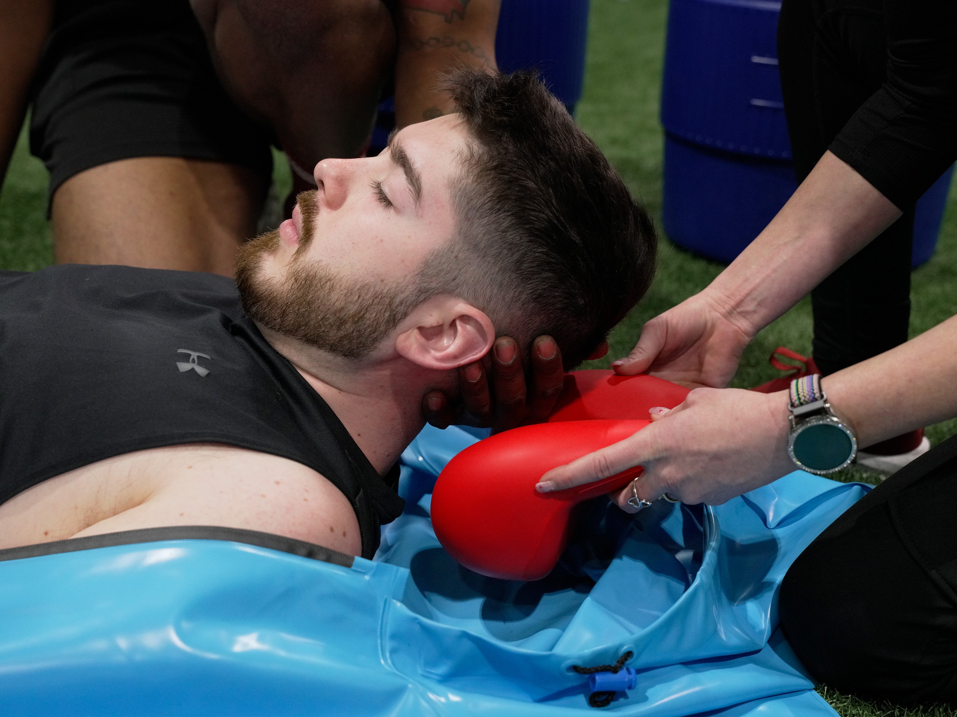 Person going into a Polar Life Pod® cold water immersion system while placing the red floating head support underneath their head and neck