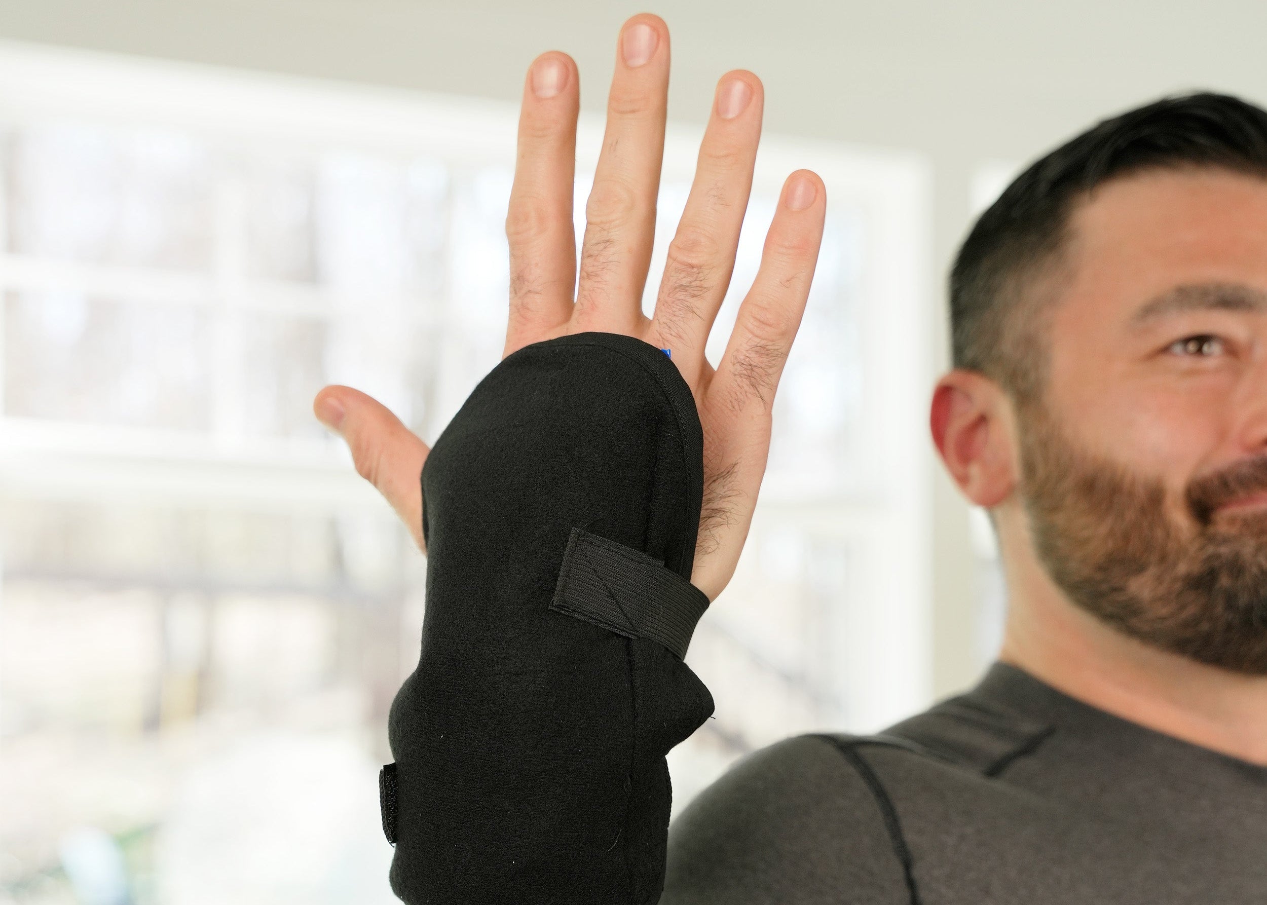 Man wearing a black Soft Ice® Wrist Wrap indoors