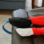 Woman in a recliner with red leggings wearing a Woman in a recliner using a Active Ice® 3.0 Knee & Joint Compression Wrap on her foot and ankle.