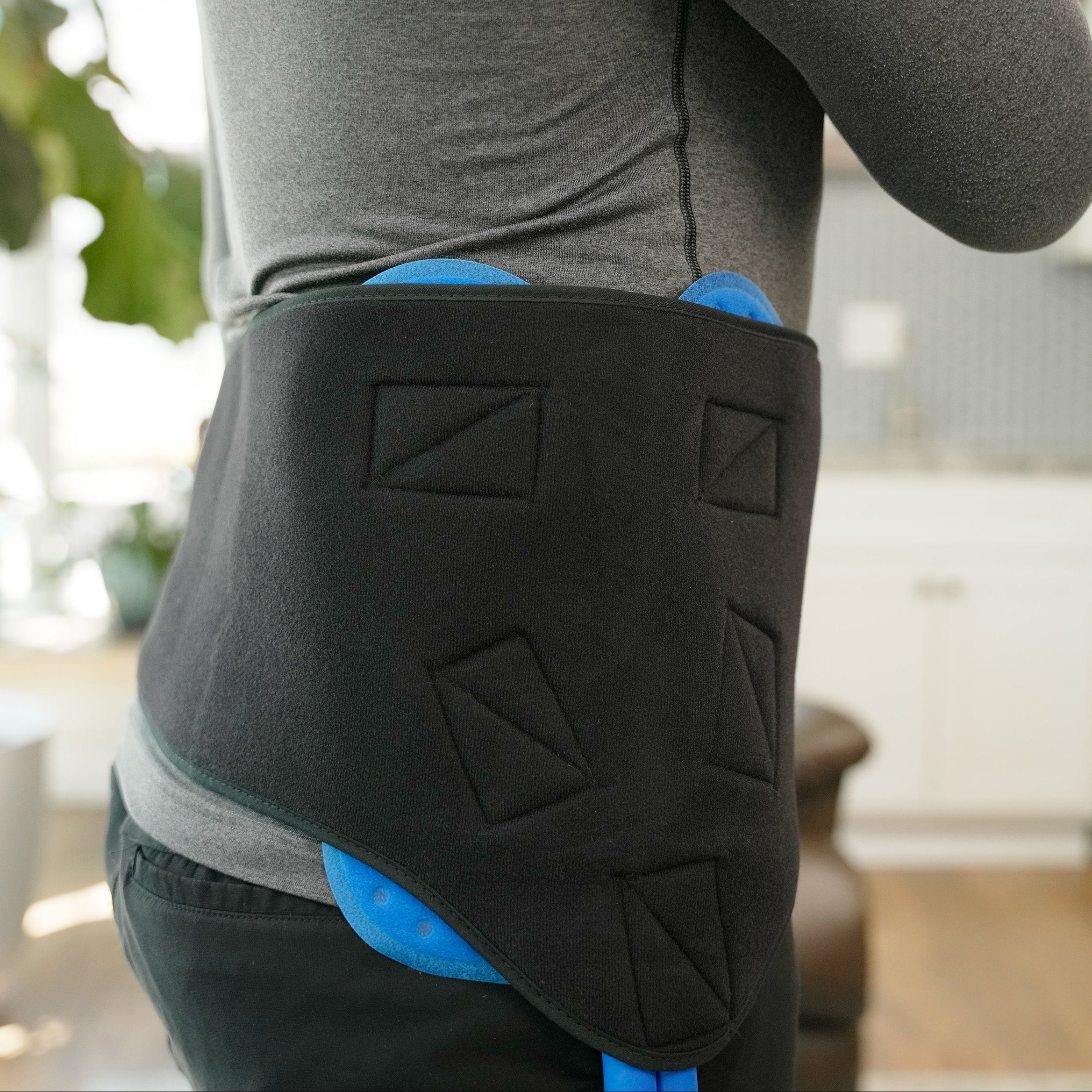 Man wearing a Active Ice® 3.0 Back or Hip Compression Wrap on his hip in a home setting.