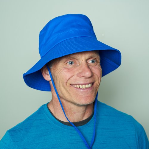 Man wearing a blue cooling bucket hat against a plain background