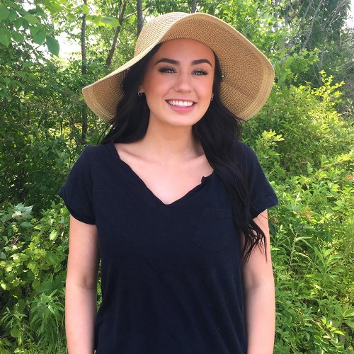 Woman wearing a Cool Comfort® straw hat and black shirt in a forest setting