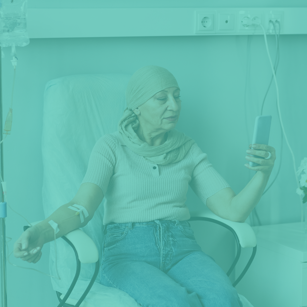 Woman in a hospital chair using a smartphone with medical equipment in the background, with a teal overlay