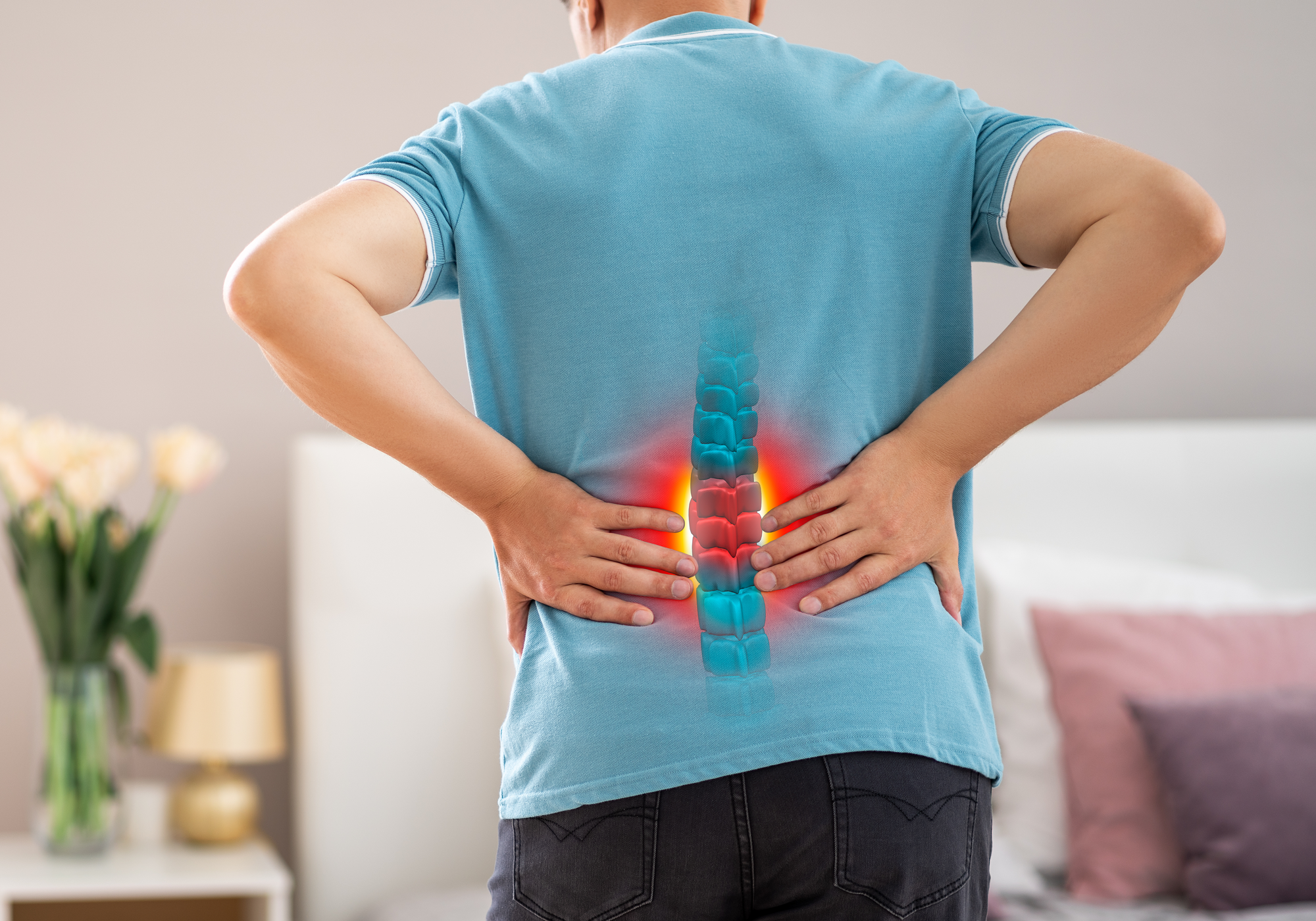 Person with highlighted spine in a blue shirt in a living room setting