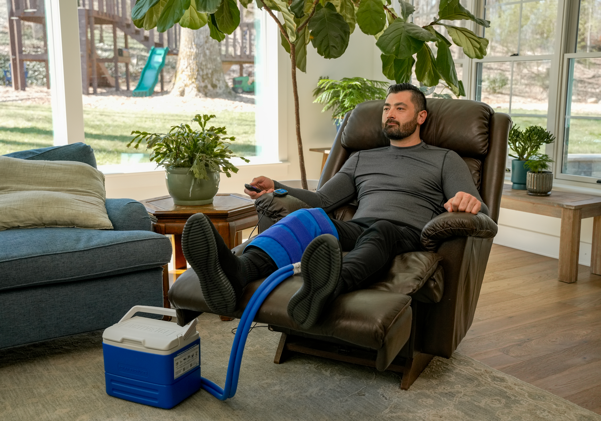 Man relaxing in a recliner with a foot massager, surrounded by home decor.