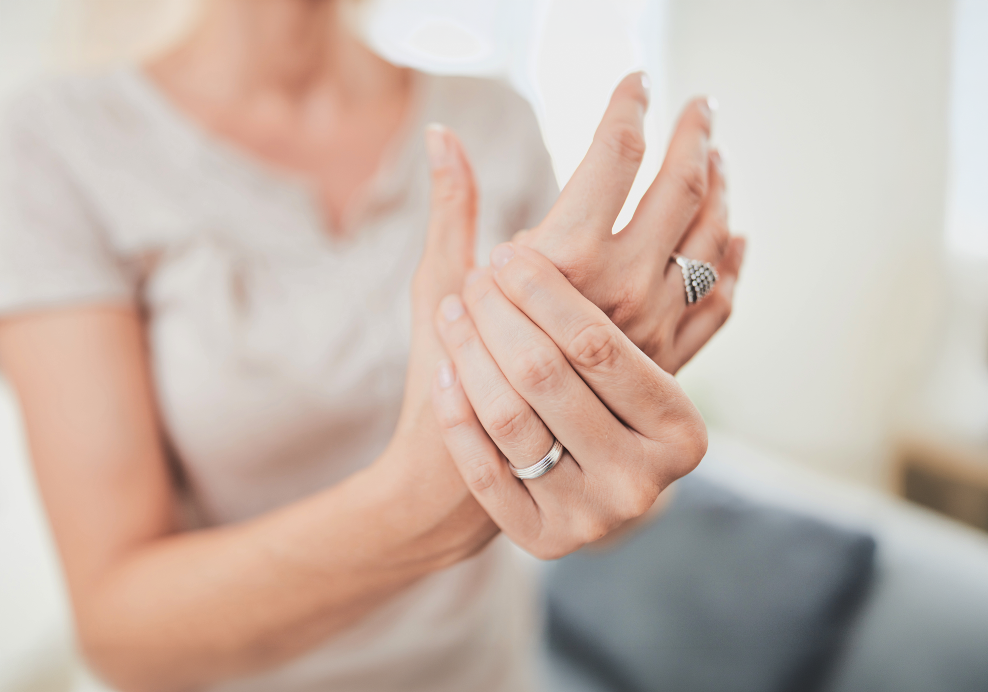 Person wearing two rings on their fingers with a blurred background