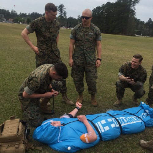 Military training exercise with with the Polar Life Pod® on a grassy field.