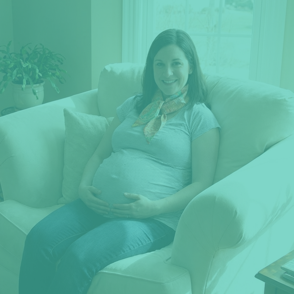 Pregnant woman sitting on a couch with a teal filter overlay