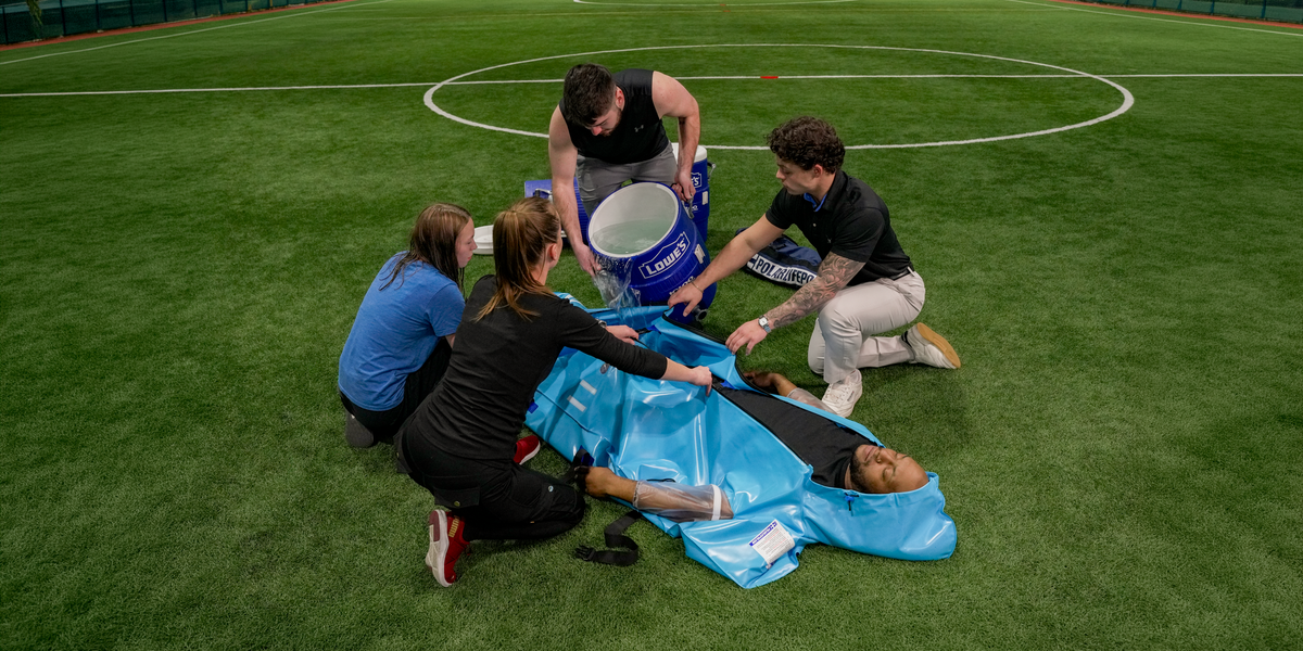 A group of athletic trainers adding water to the Polar Life Pod