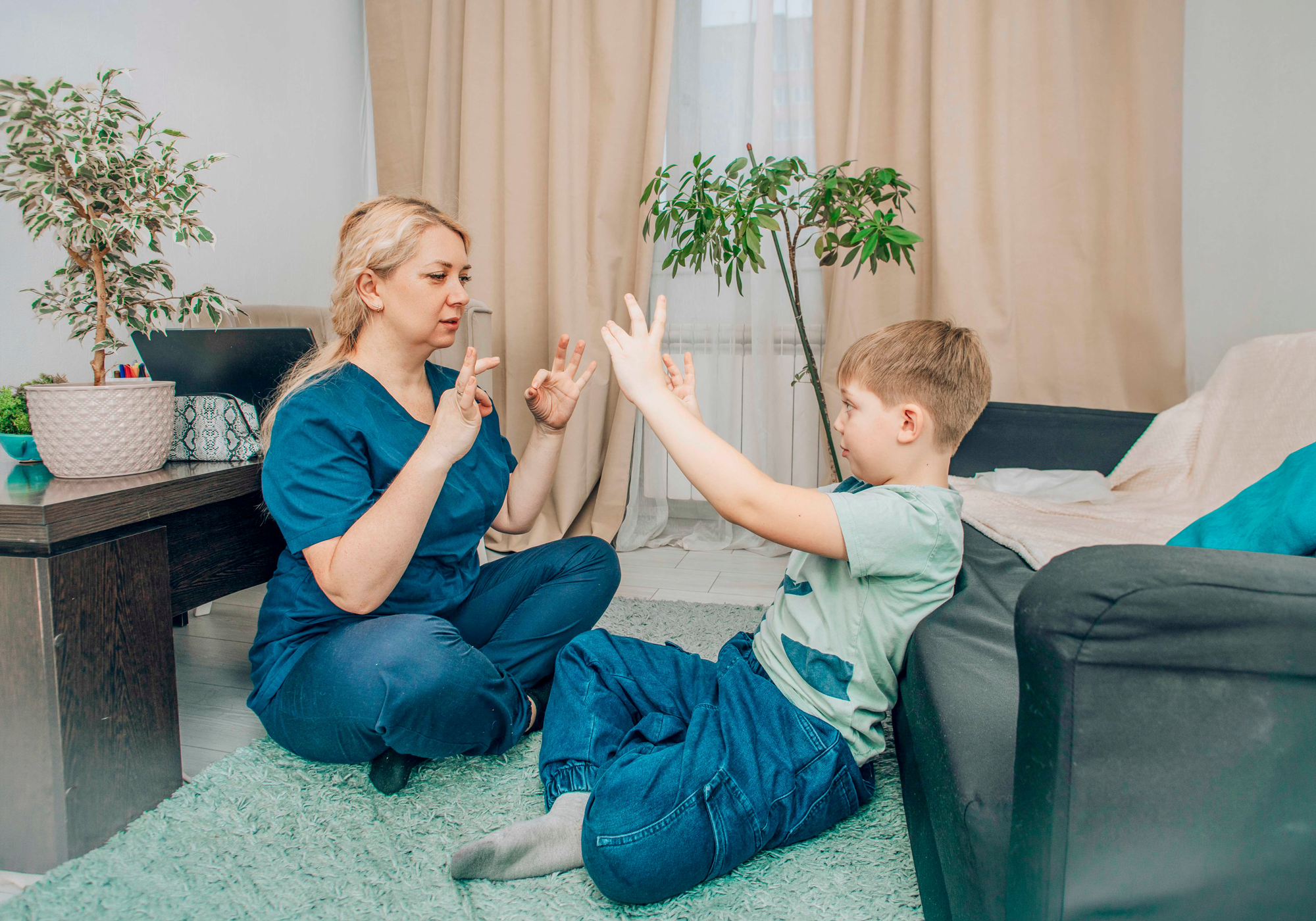 Woman and child in a home setting, possibly engaging in a therapeutic activity.