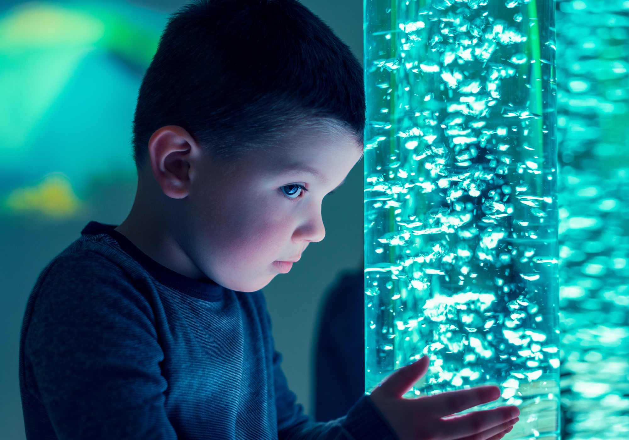 Child interacting with a glowing blue light display